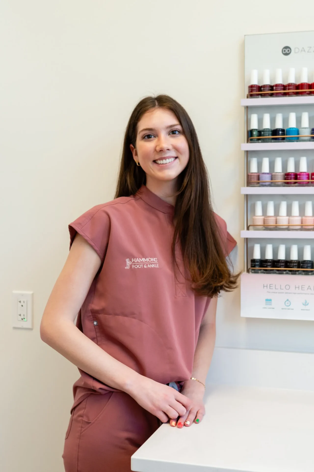 A woman standing in front of shelves with nail polish.