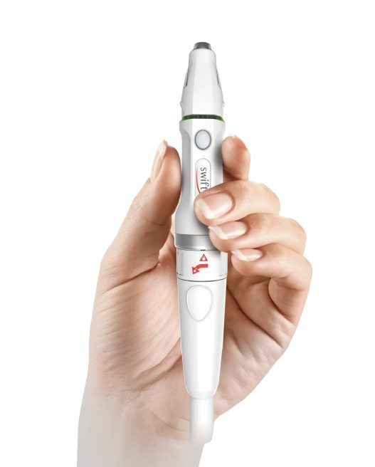 A person holding an electric toothbrush in their hand.