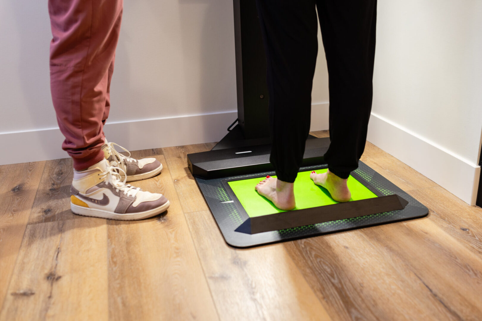 Two people standing on a scale in the middle of a room.